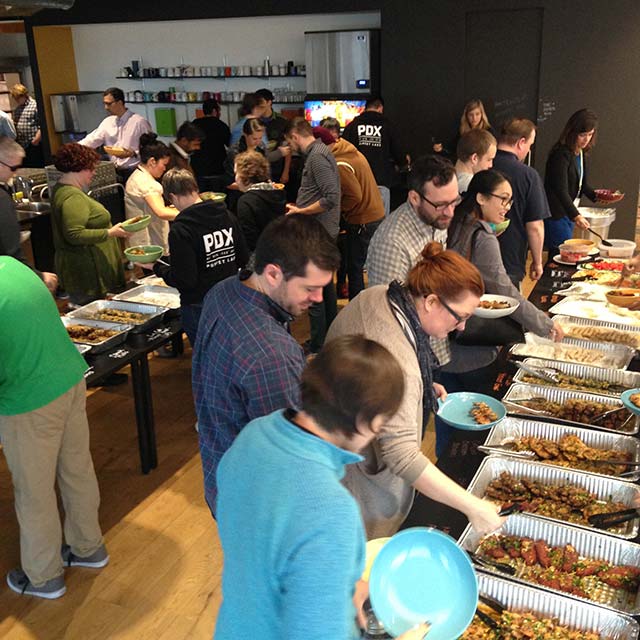 Hungry people filling up their plates at a catering event